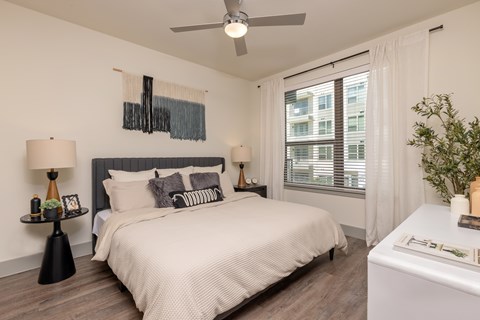 A bedroom with a large bed and a ceiling fan.