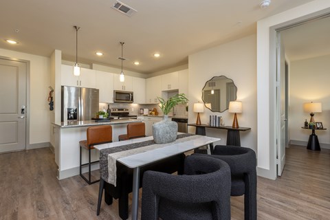 A modern kitchen with a dining table and chairs.