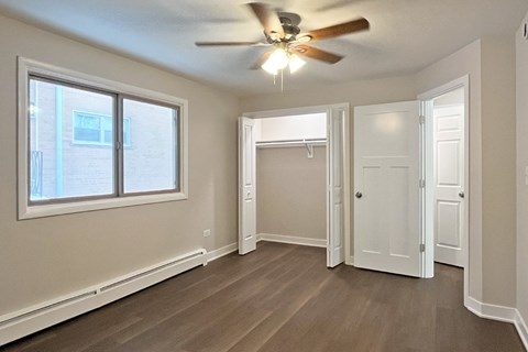 A room with a ceiling fan and a window.