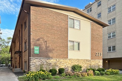 A brick building with a green sign on the left side.
