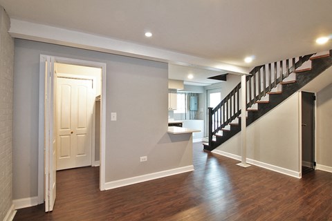 A hallway with a staircase and a white door.