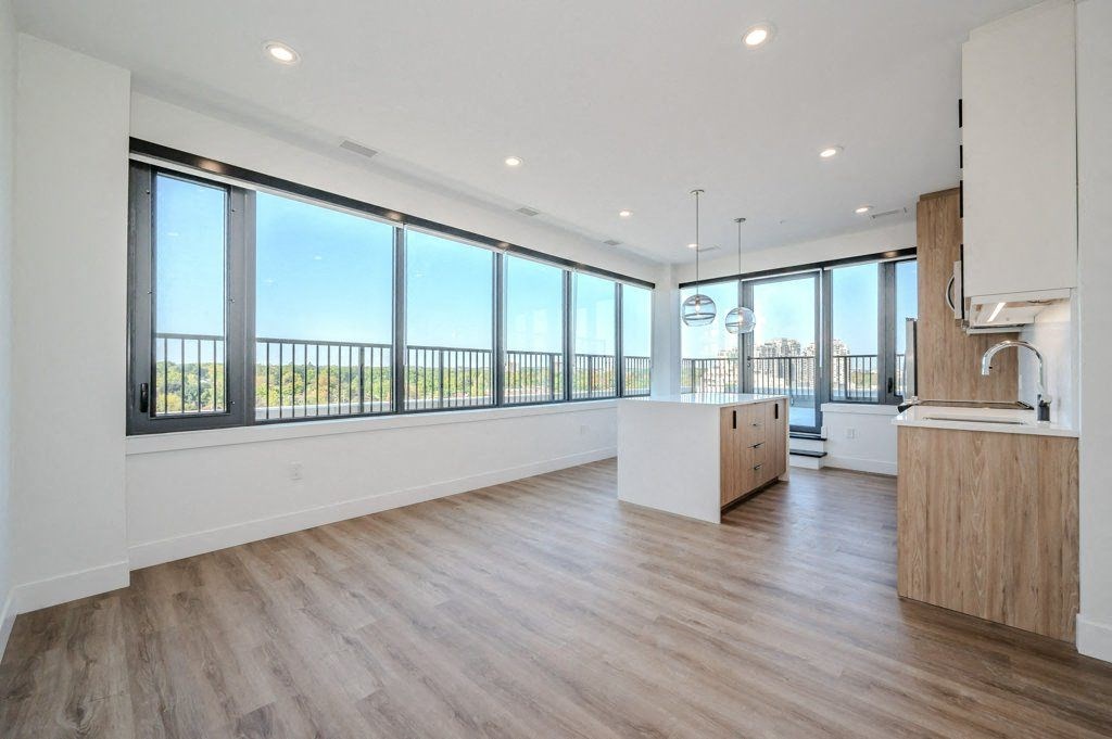 a large living room with a kitchen and a large amount of windows