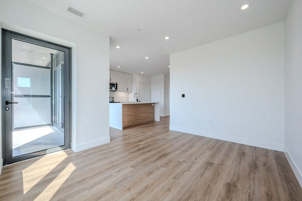 a living room with a sliding glass door to a kitchen