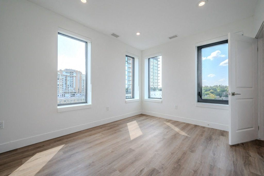 a living room with a hard wood floor and three windows