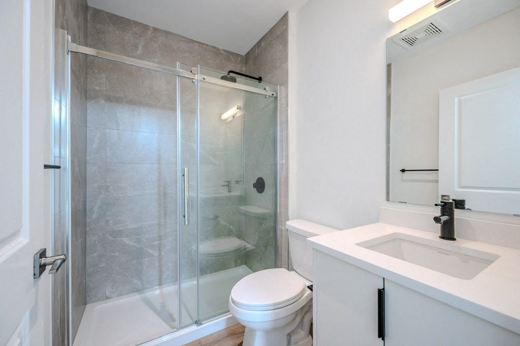 a bathroom with a shower and a sink and a toilet