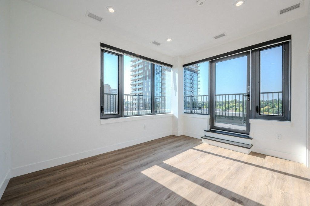 an empty living room with large windows and a balcony