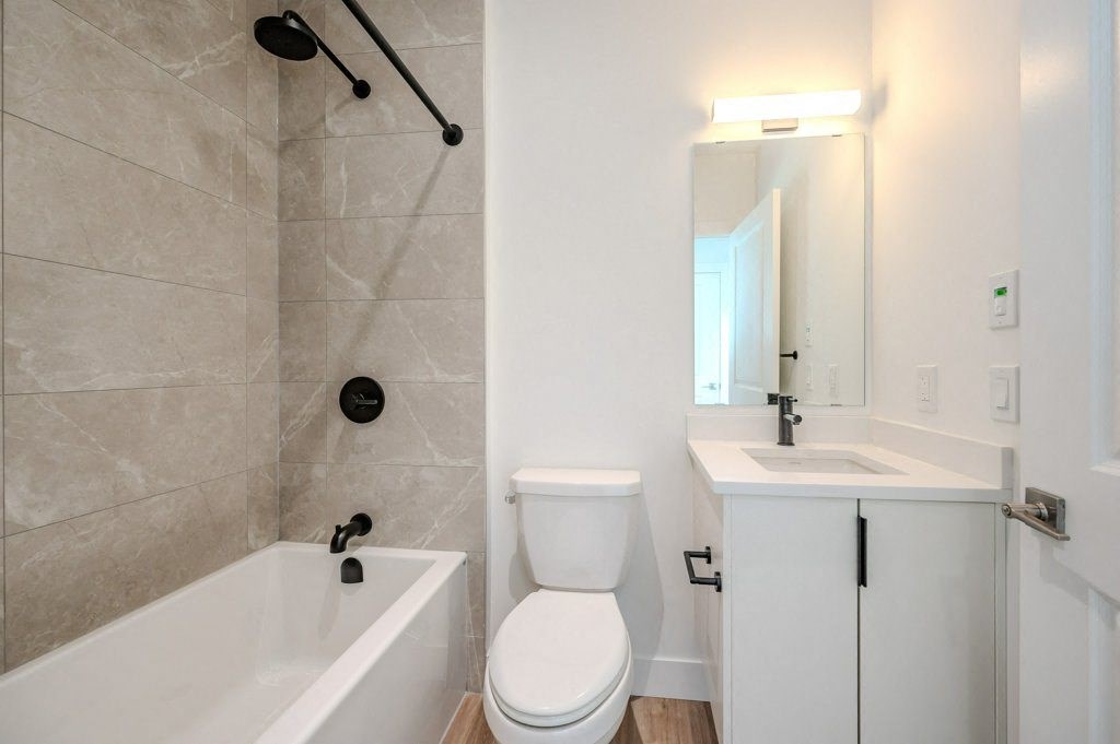 a bathroom with a toilet sink and tub and a mirror