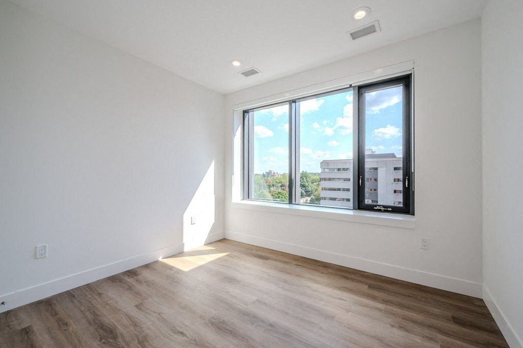 a living room with a large window and wooden floors