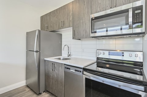A modern kitchen with stainless steel appliances and wooden cabinets.