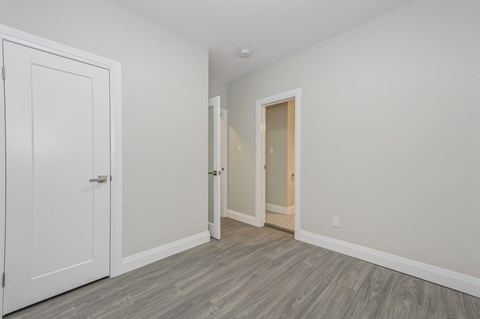 A room with a white door and a grey floor.