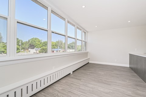 A room with a long window wall and a wood floor.