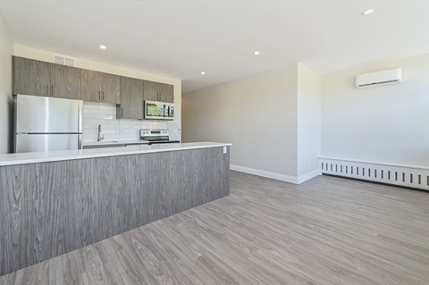 A kitchen with a refrigerator, oven, and microwave.