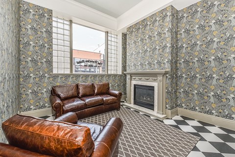 A living room with a fireplace and leather furniture.