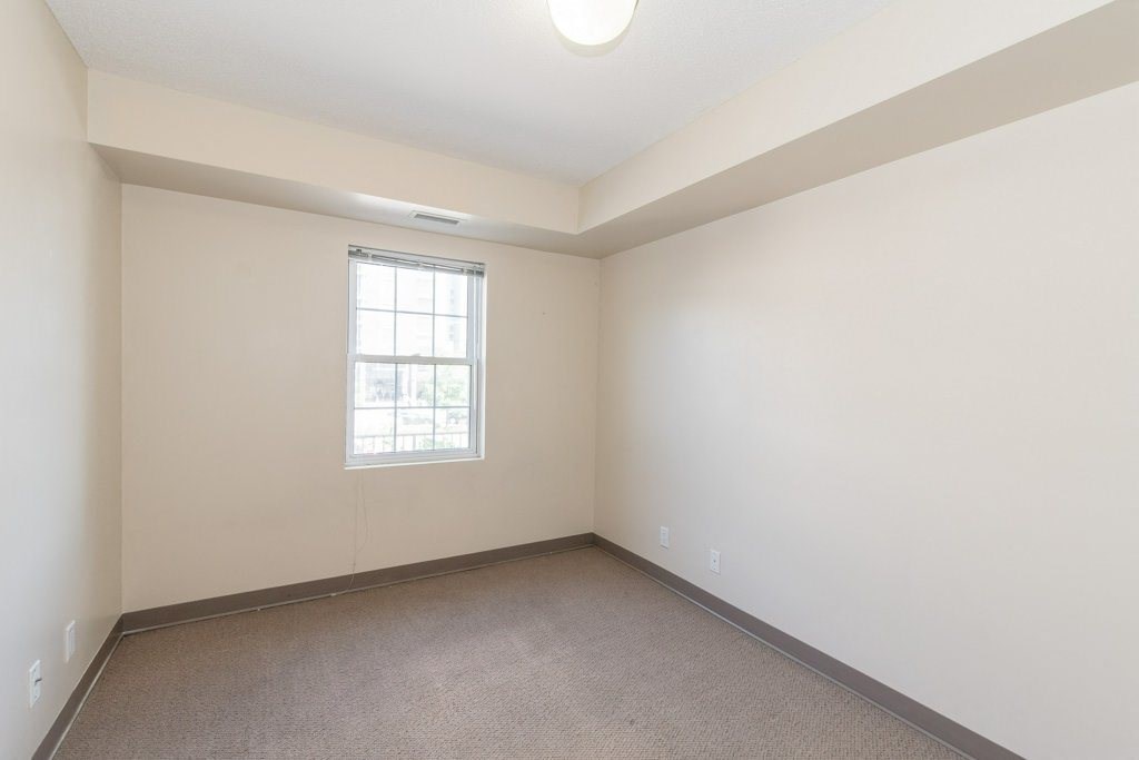 A room with a window and carpeted floor.