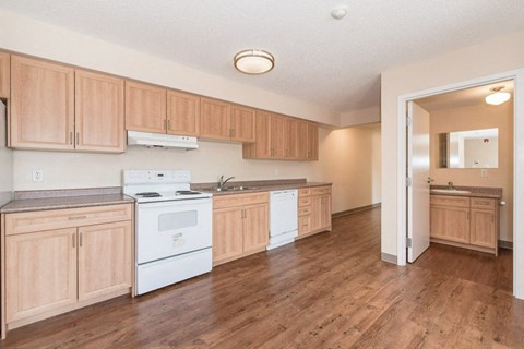 A kitchen with wooden cabinets and a white stove top oven.