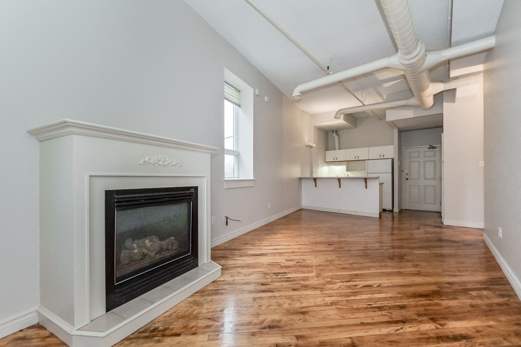 A room with a fireplace and wooden floors.