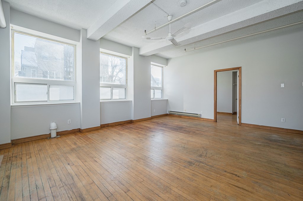 Empty room with wooden floors and white walls.