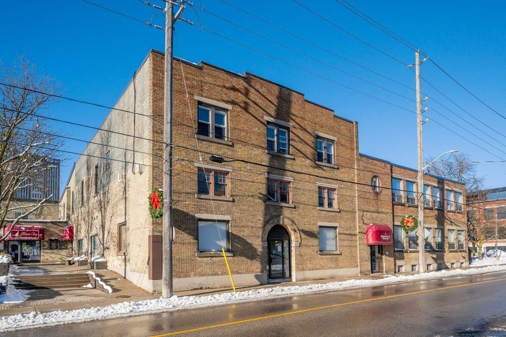 A large brick building with a red awning on the corner.