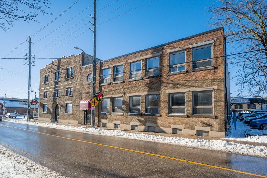 A brick building with a red and white sign on the front.