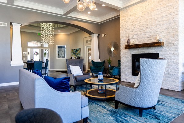 A living room with a fireplace and a grey couch.