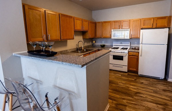 A kitchen with wooden cabinets and a white fridge.