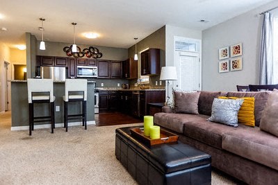 A living room with a brown couch and a black coffee table.