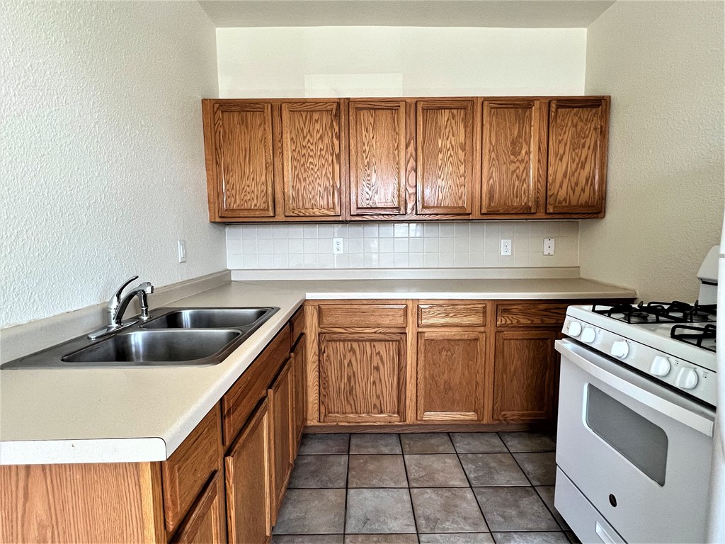 a kitchen with wooden cabinets and white appliances