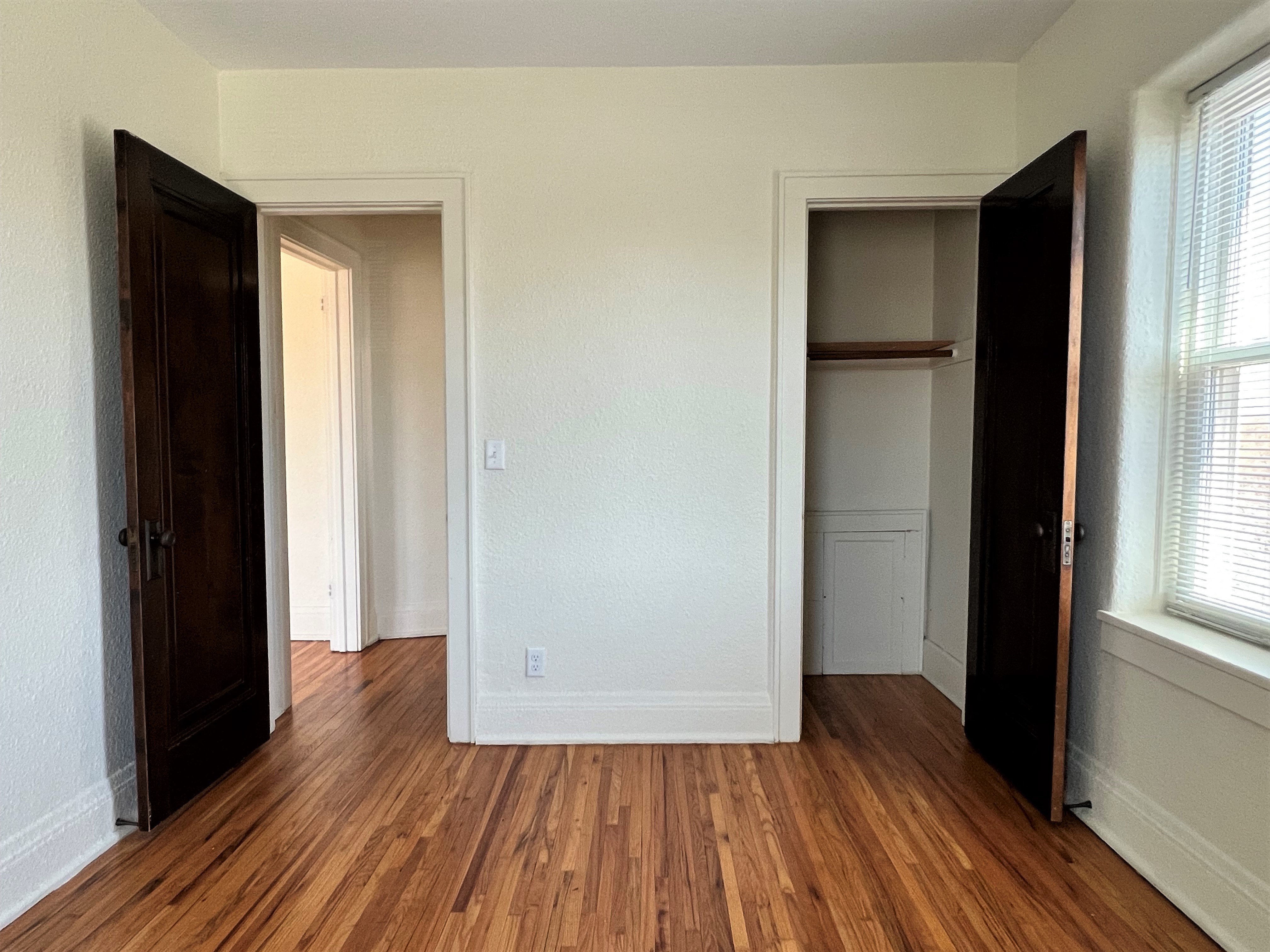 a living room with wood floors and a closet