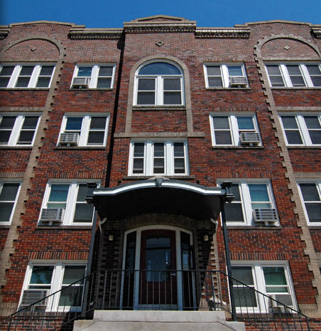 a red brick building with a balcony and a door