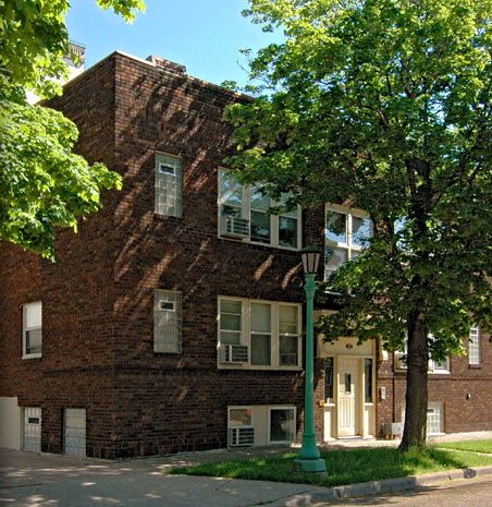 a red brick building with a tree in front of it