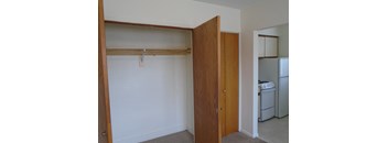 a bedroom with a closet and a laundry room with a washer and dryer