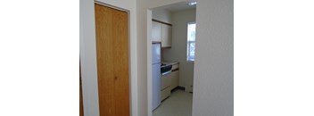 a view of a kitchen from the doorway of an empty room