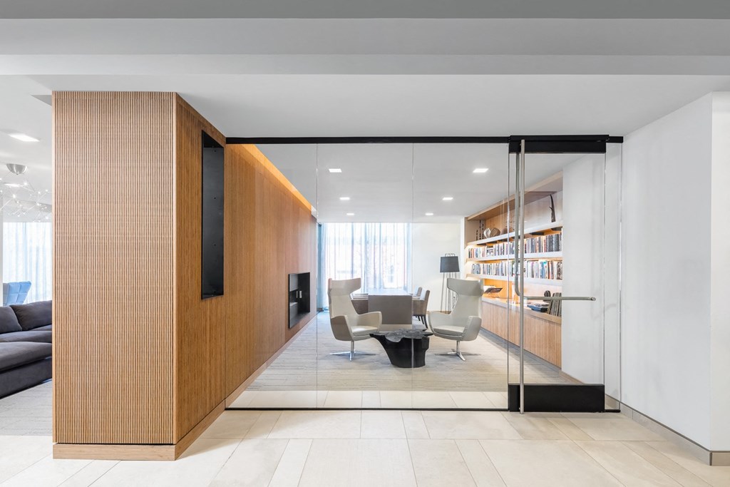 a room with a table and chairs and a bookshelf on the side of the room