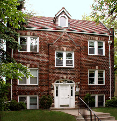a red brick house with a white door and windows