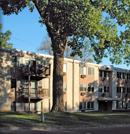 an apartment building with a tree in front of it