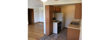an empty kitchen with a refrigerator and a sink