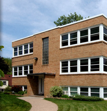 a brick building with a sidewalk in front of it