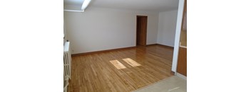 an empty living room with wooden floors and a door