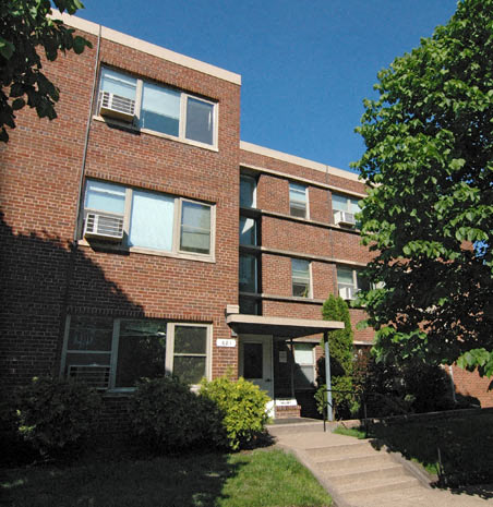 a brick building with a sidewalk in front of it