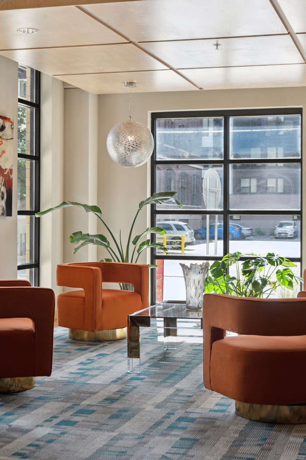 a lobby with orange chairs and a glass coffee table
