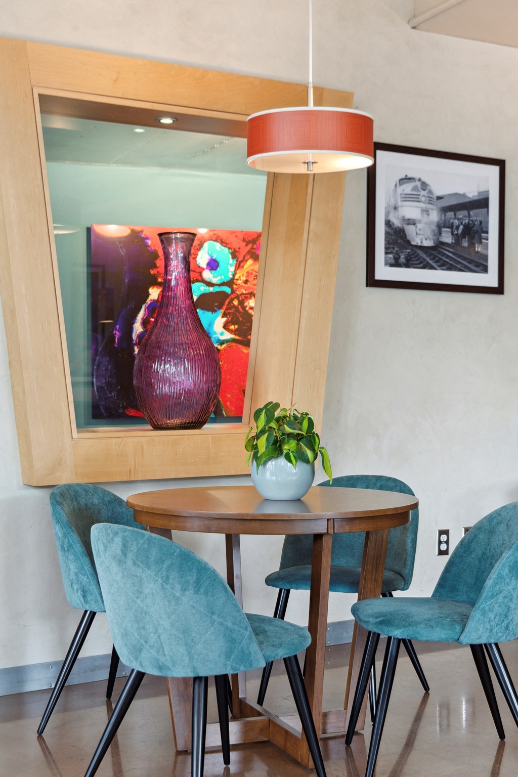 a small dining area with a round table and four blue chairs