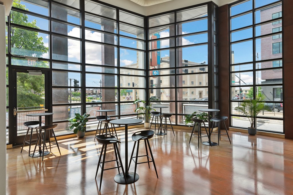 a room with floor to ceiling windows and tables and chairs