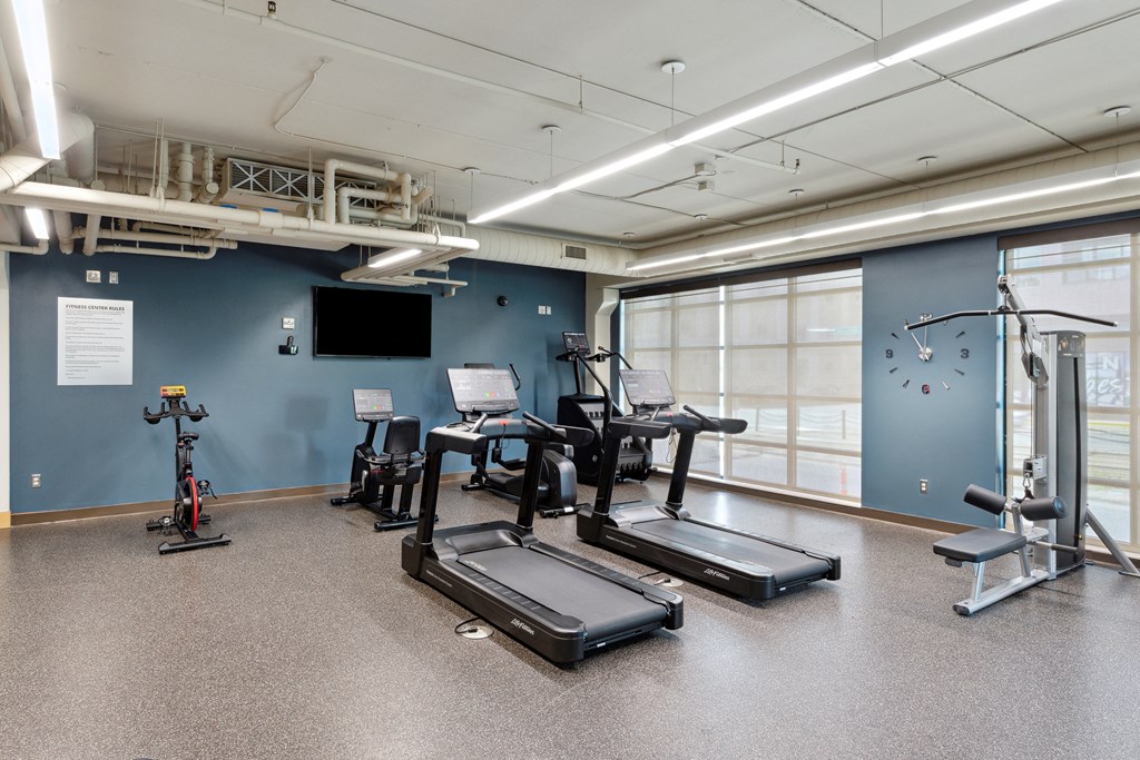 a workout room with treadmills and other exercise equipment