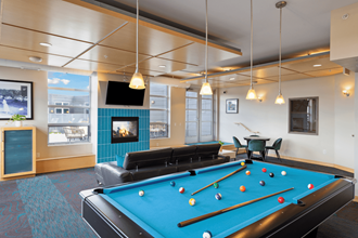 a games room with a pool table and a fireplace