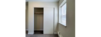 a closet in the corner of a room with a window and