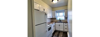 a kitchen with white cabinets and a white refrigerator