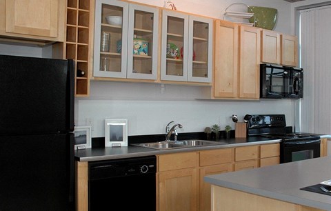 a kitchen with black appliances and wooden cabinets
