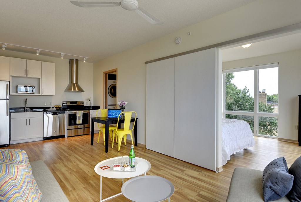 Kitchen and glimpse into bedroom with oversized windows in the Flat H, 1 bedroom floor plan at Coze Flats