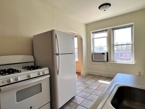 an empty kitchen with a stove and refrigerator