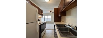 an empty kitchen with a sink and a refrigerator
